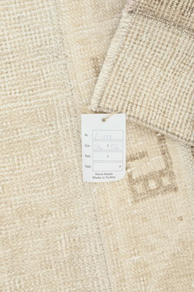 Close-up of the rug's label, indicating 'Hand Knotted' and 'Made in Turkey' next to the pile.
