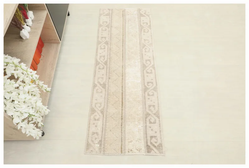 Full top view of the beige tribal geometric runner rug on a white background.