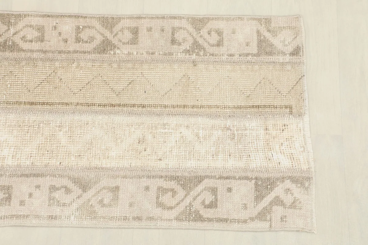 Close-up view of the rug's patterns and colors, highlighting the geometric motifs.