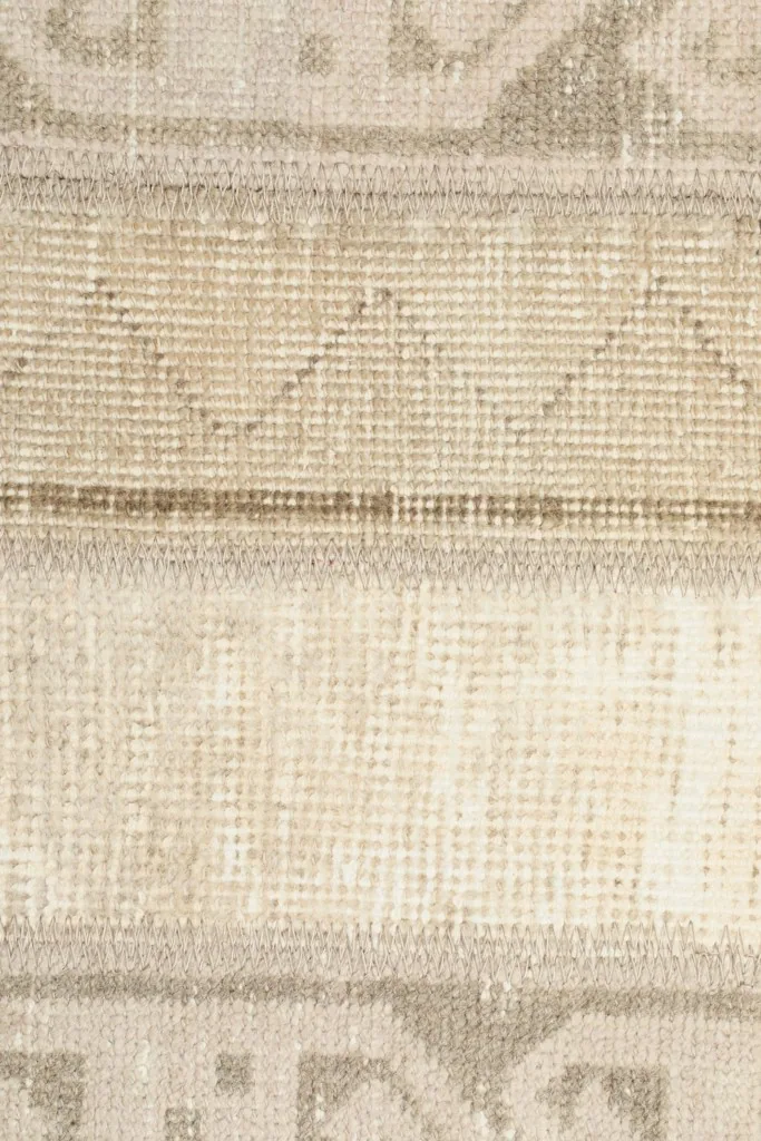 Extreme close-up of the hand-knotted wool pile and cotton foundation.