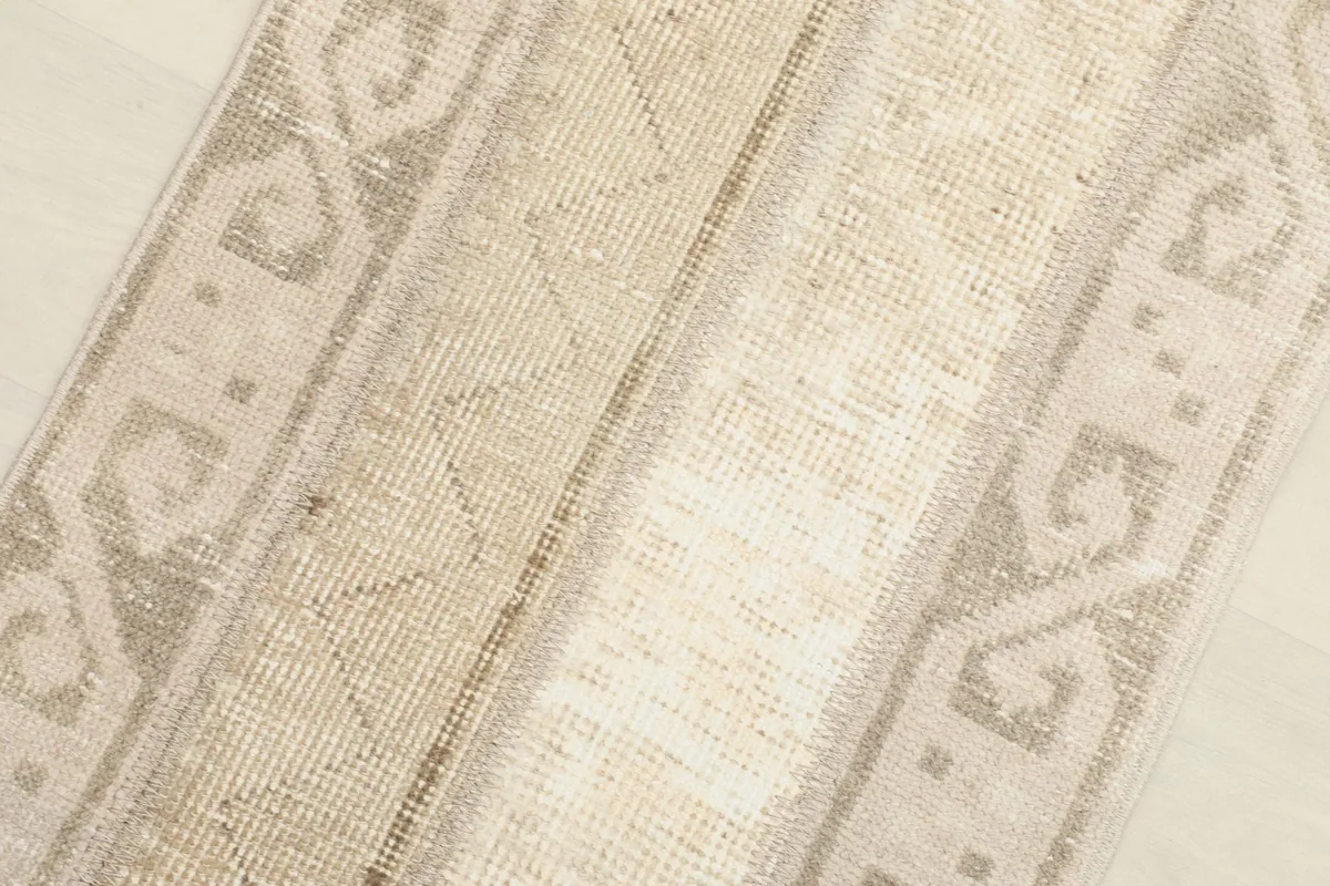 Close-up of the rug's low pile and weave texture, showing slight variations in color.