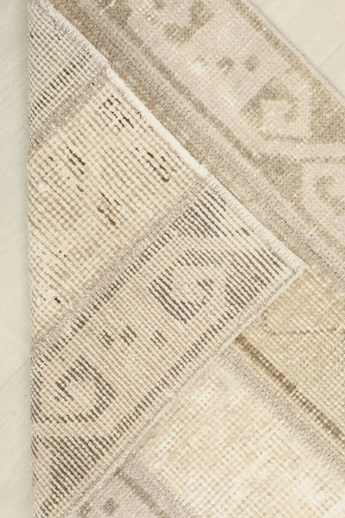 View of the rug's reverse side, revealing the knotting and foundation structure.