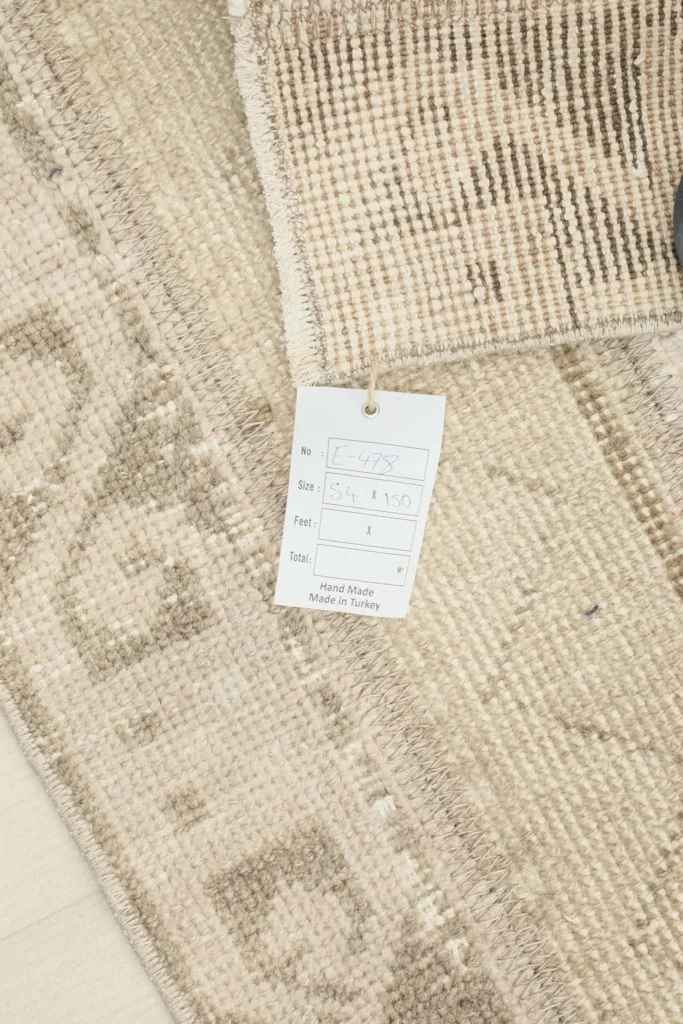 Close-up of the RugsKilim tag attached to the back of the hand-knotted Anatolian runner.