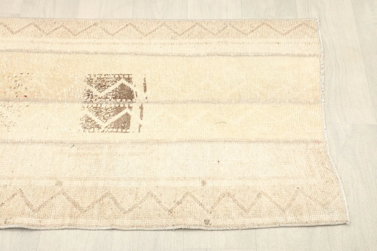 Angled view of the rug's right side, displaying the subtle variations in the ivory and beige tones.