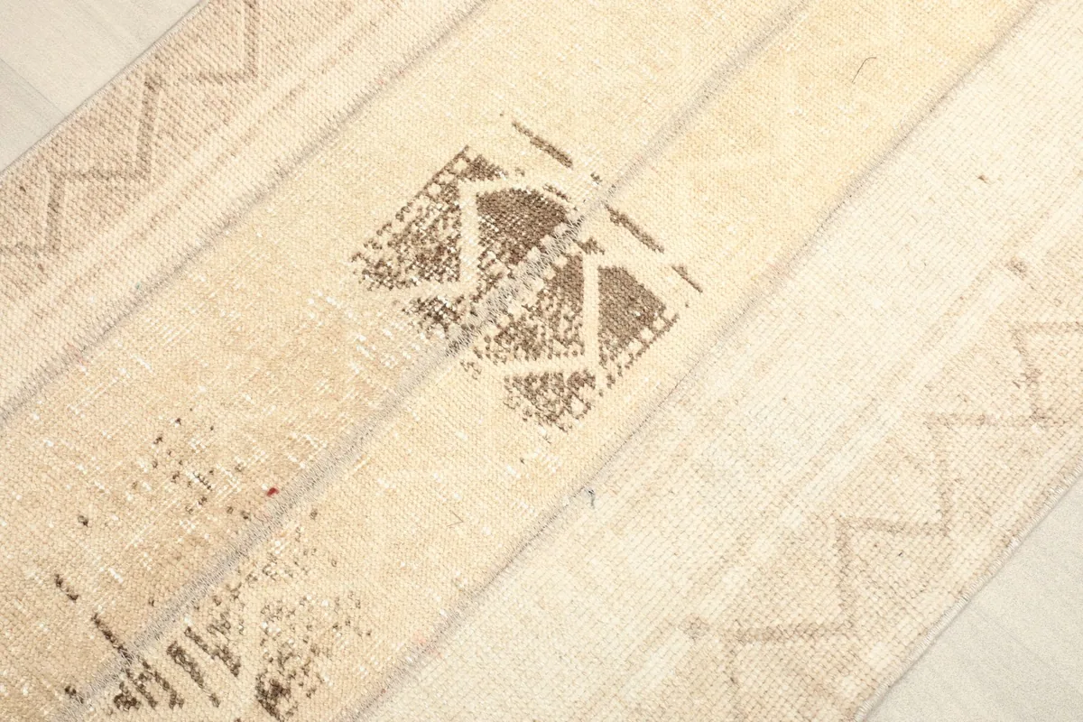 Angled close-up of the central brown geometric motif and surrounding zigzag patterns.