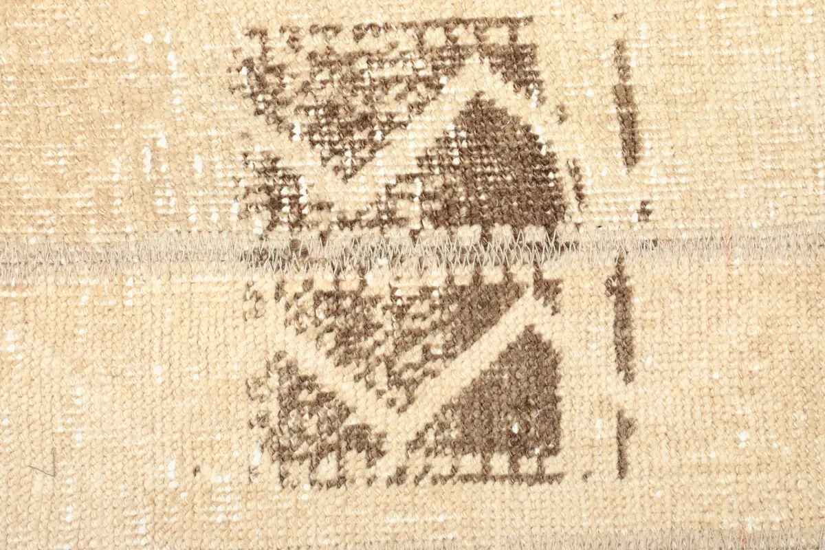 Close-up of the central brown tribal motif, highlighting its texture and faded appearance.