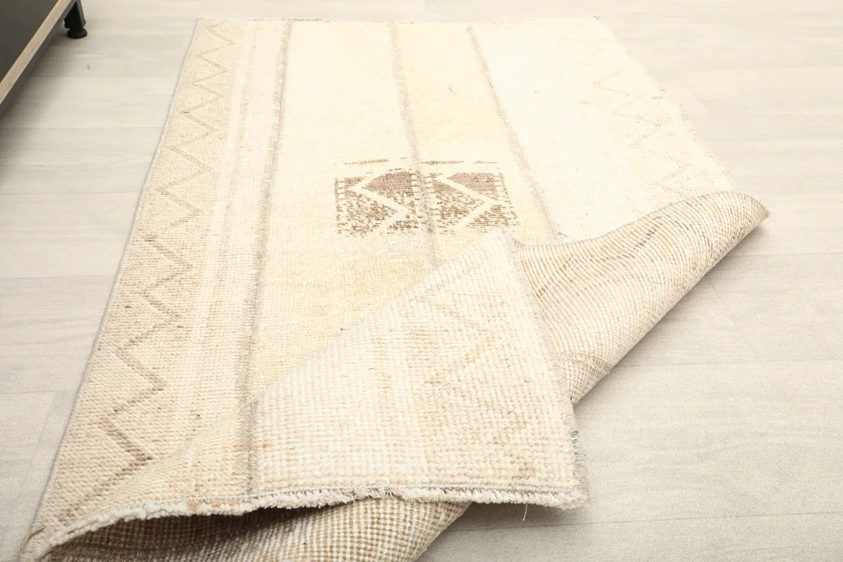 The rug folded back, showing the thickness of the wool pile and the construction.