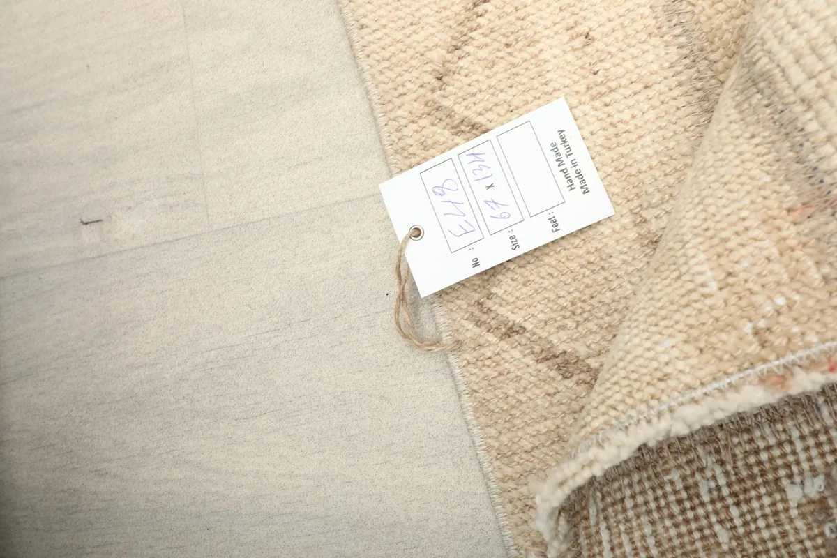 A close-up of the rug's label, indicating its hand-knotted origin and dimensions.