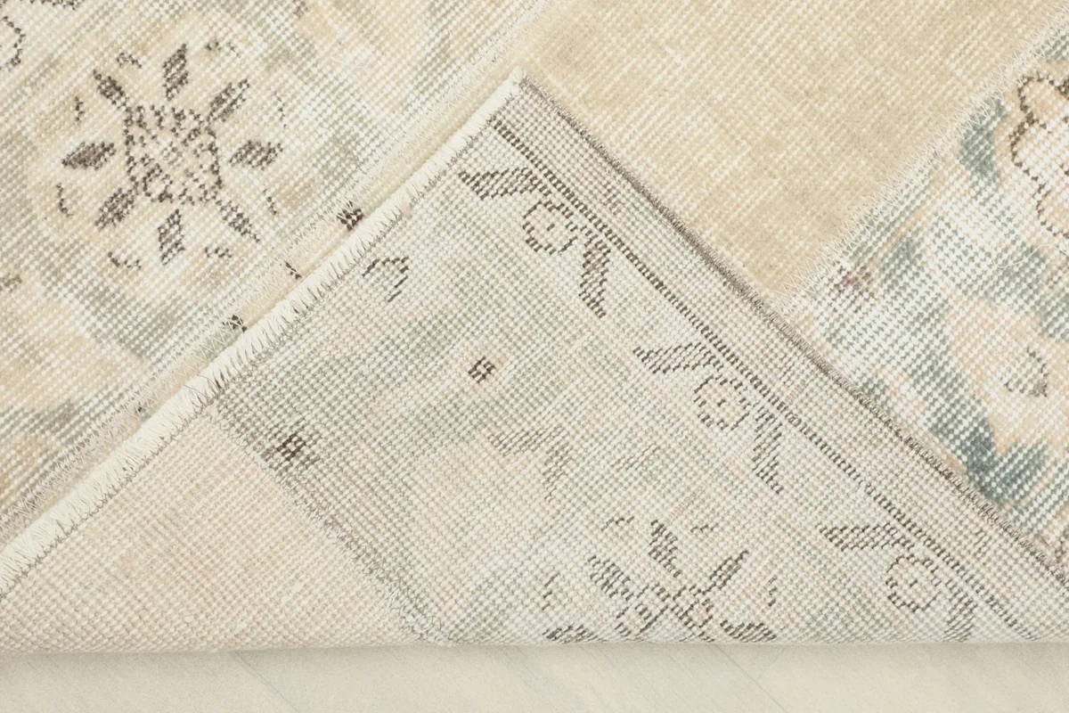 View of the back of the hand-knotted rug, revealing the cotton foundation and knotting structure.