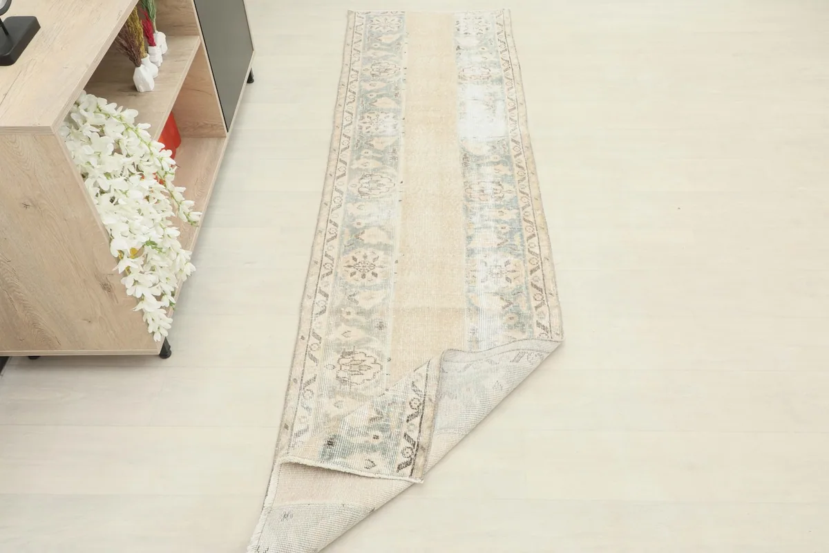 The runner rug partially folded, showing the flexibility and thickness of the wool pile.
