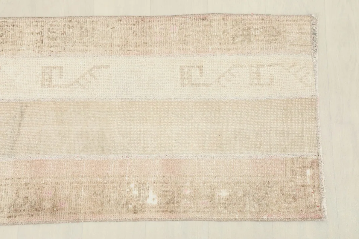 Close-up of one end of the runner, highlighting patchwork seams and faded geometric patterns.