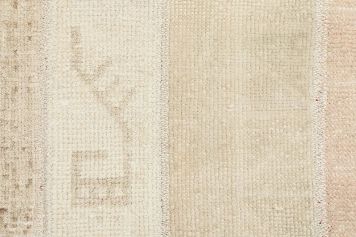 Extreme close-up of the rug's pile, revealing the hand-knotted construction and faint motifs.
