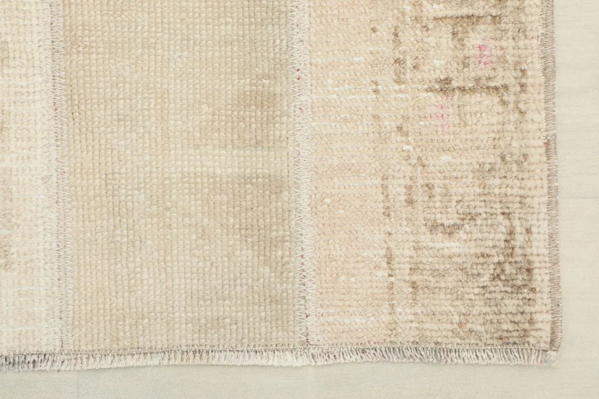 Close-up of the rug's edge, showing the finished side and a corner of the patchwork.