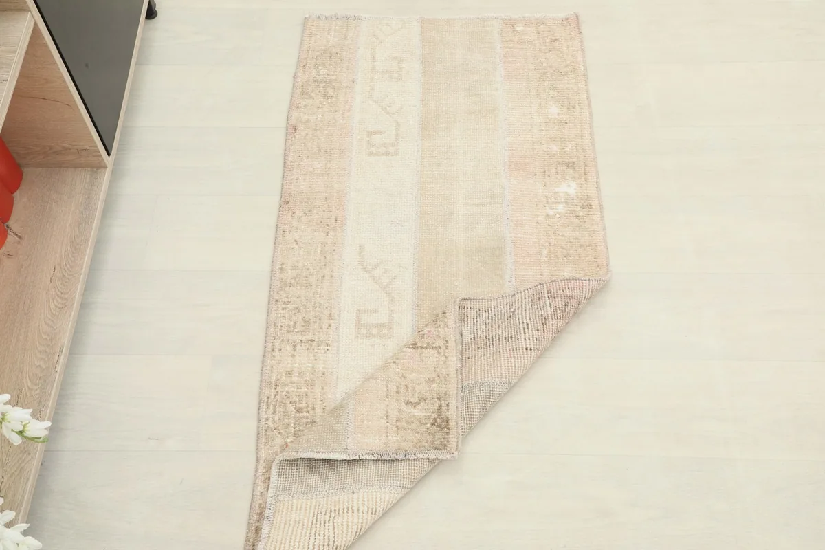 The rug partially folded, illustrating its flexibility and construction from an overhead perspective.