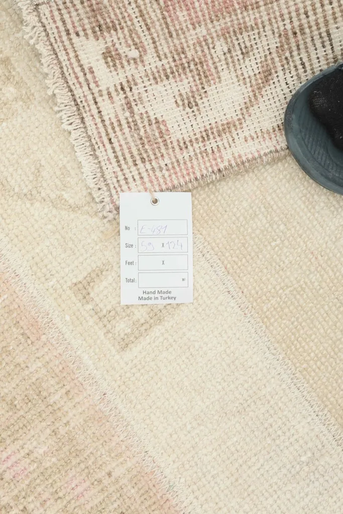 Close-up of the rug with a product tag, indicating its hand-knotted origin in Turkey.