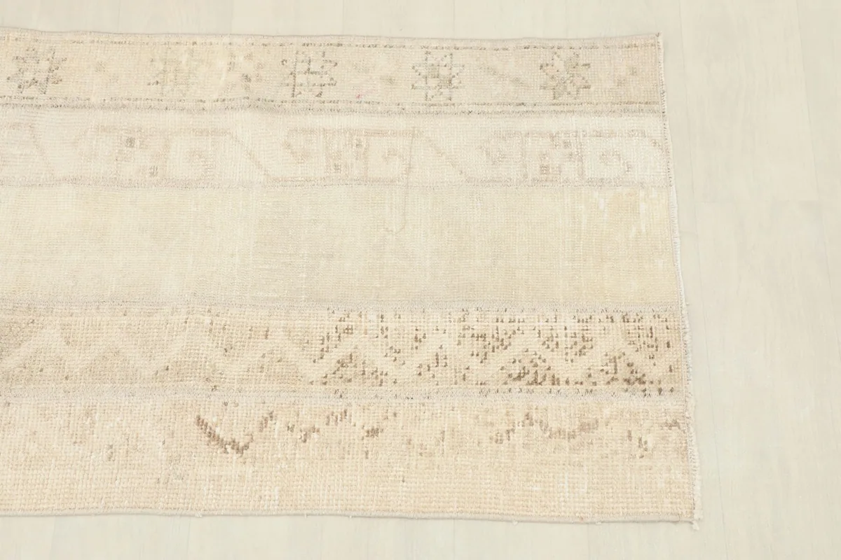 Close-up of the rug's surface, highlighting faded tribal geometric motifs and texture.