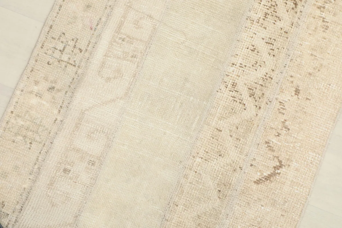 Detailed view showing the wool pile and the distressed nature of the vintage rug.