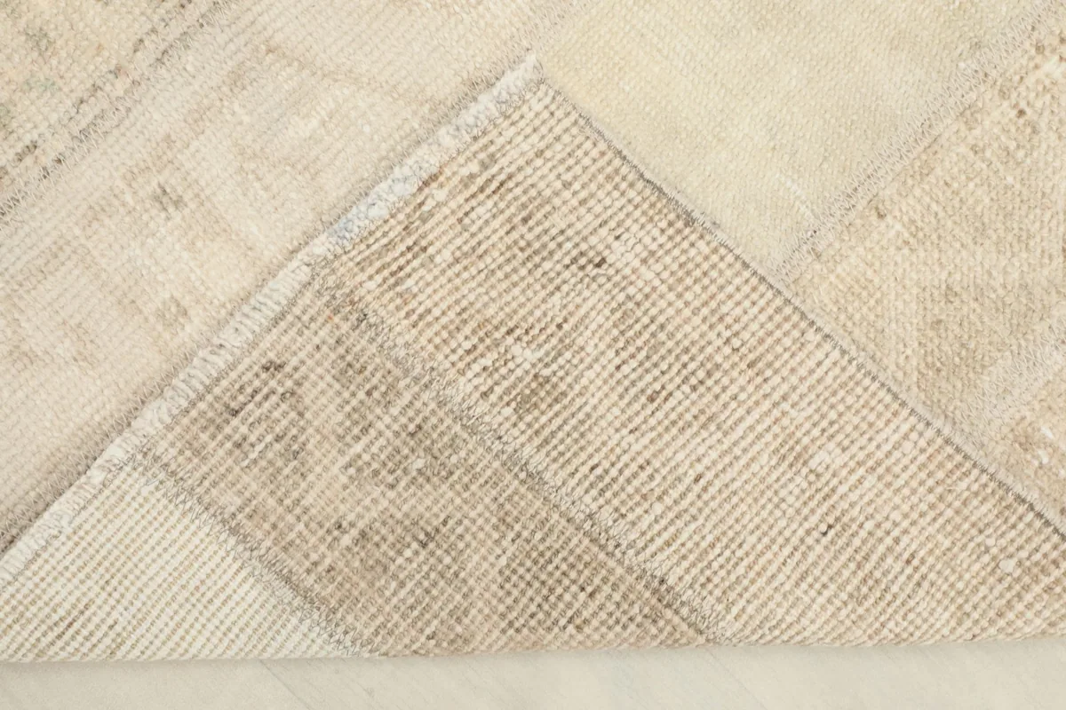 Corner flipped to show the cotton foundation and the reverse side of the hand-knotted rug.