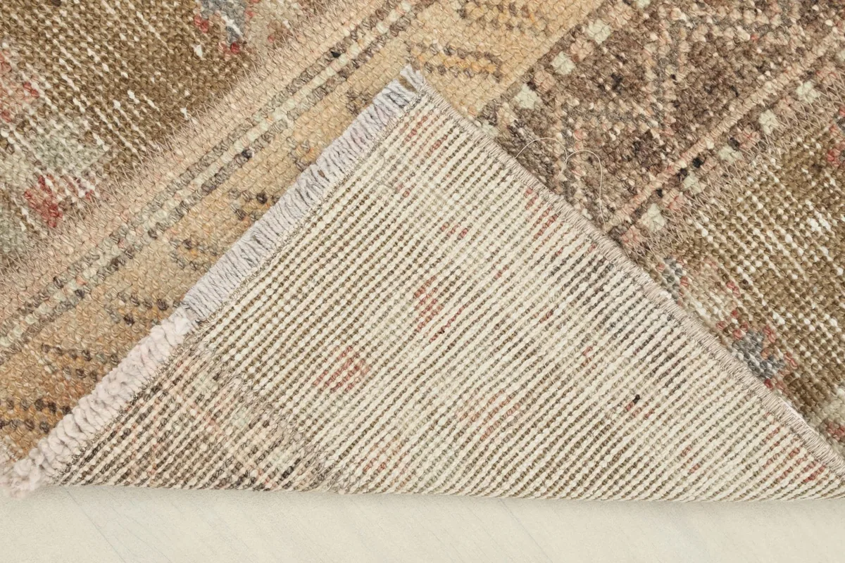 View of the back of the rug, revealing its hand-knotted cotton foundation.