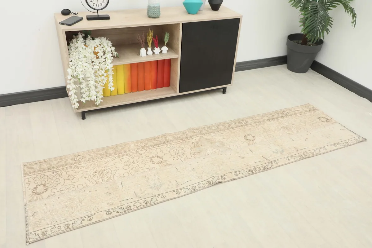 Overhead view of the beige vintage runner rug in a room setting next to a console table.