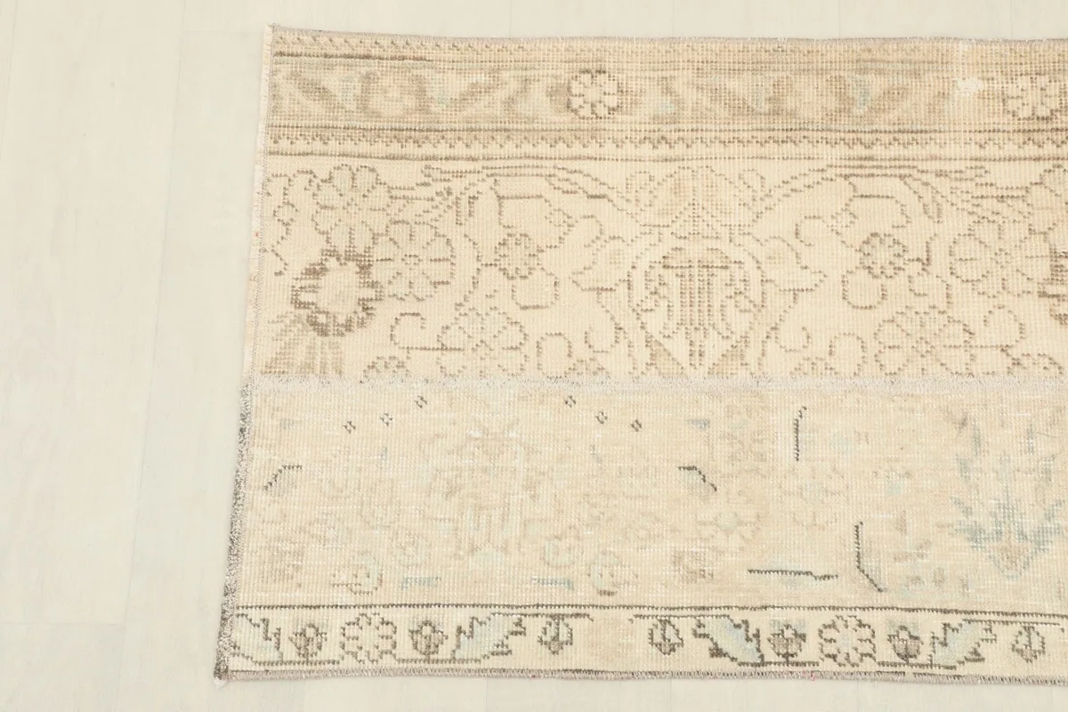 Detailed view of the rug's patterns, highlighting the subtle color variations and vintage wear.