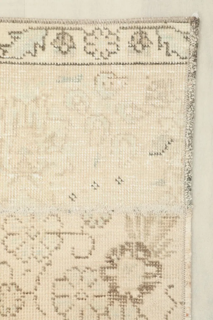 Detail of the rug's border and corner, showing the edge finish and pattern.