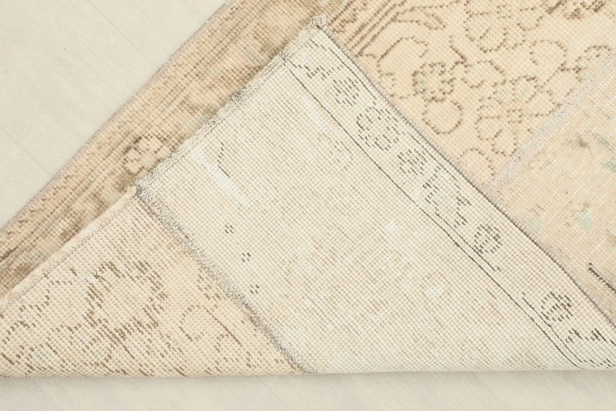 View of the back of the hand-knotted wool rug, revealing its cotton foundation.