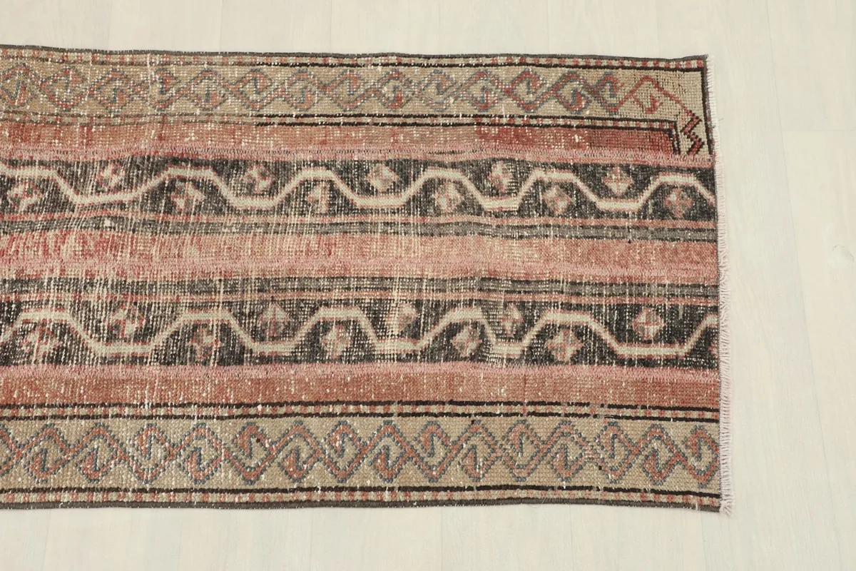 Close-up of the runner's top end, highlighting the rose, gray, and beige striped design