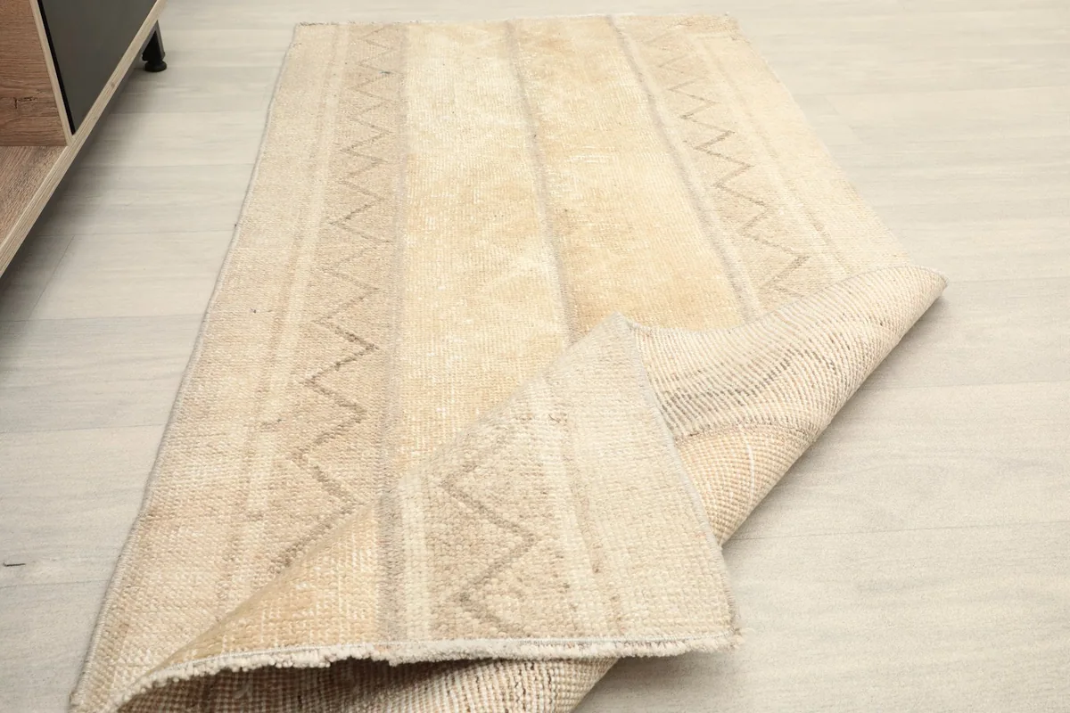 The rug partially folded, showing the texture of the low wool pile