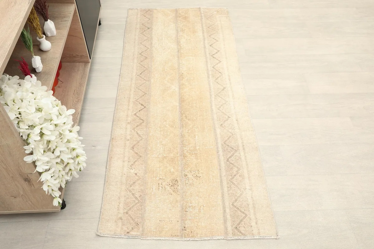 Overhead view of the beige rug, showing its full length and geometric striped pattern