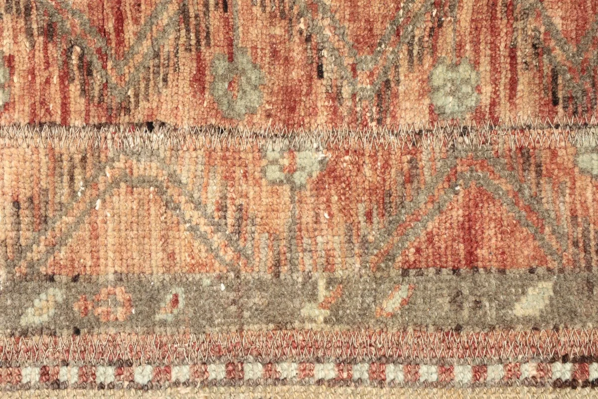 Macro detail of the central rust-toned stripe, revealing subtle geometric patterns and the low pile.