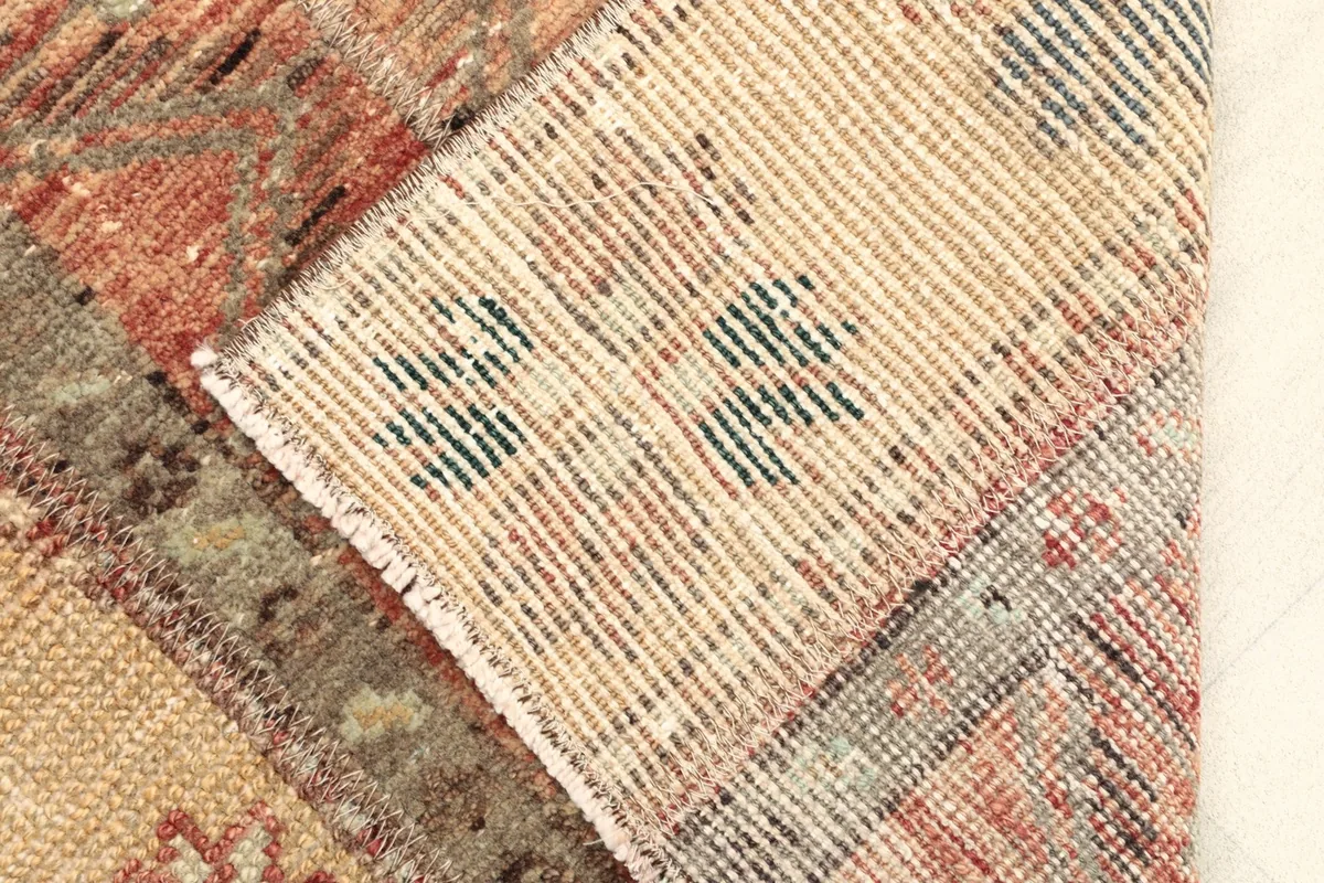 A folded section of the rug, illustrating the wool pile texture and the cotton foundation underneath.