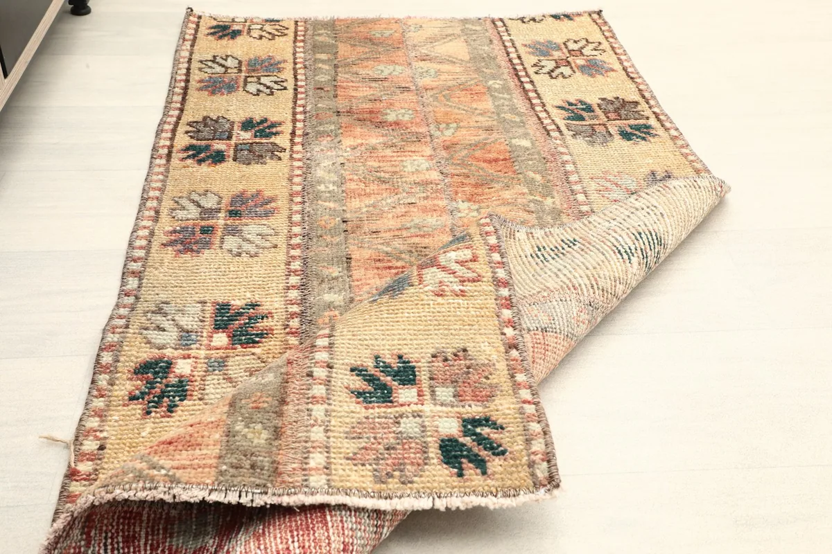 The rug partially folded to show its flexibility and the reverse side of the hand-knotted construction.