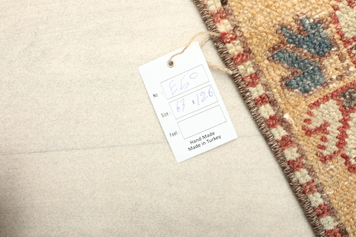 Close-up of the rug's corner with a tag indicating 'Hand Made Made in Turkey' and the size.