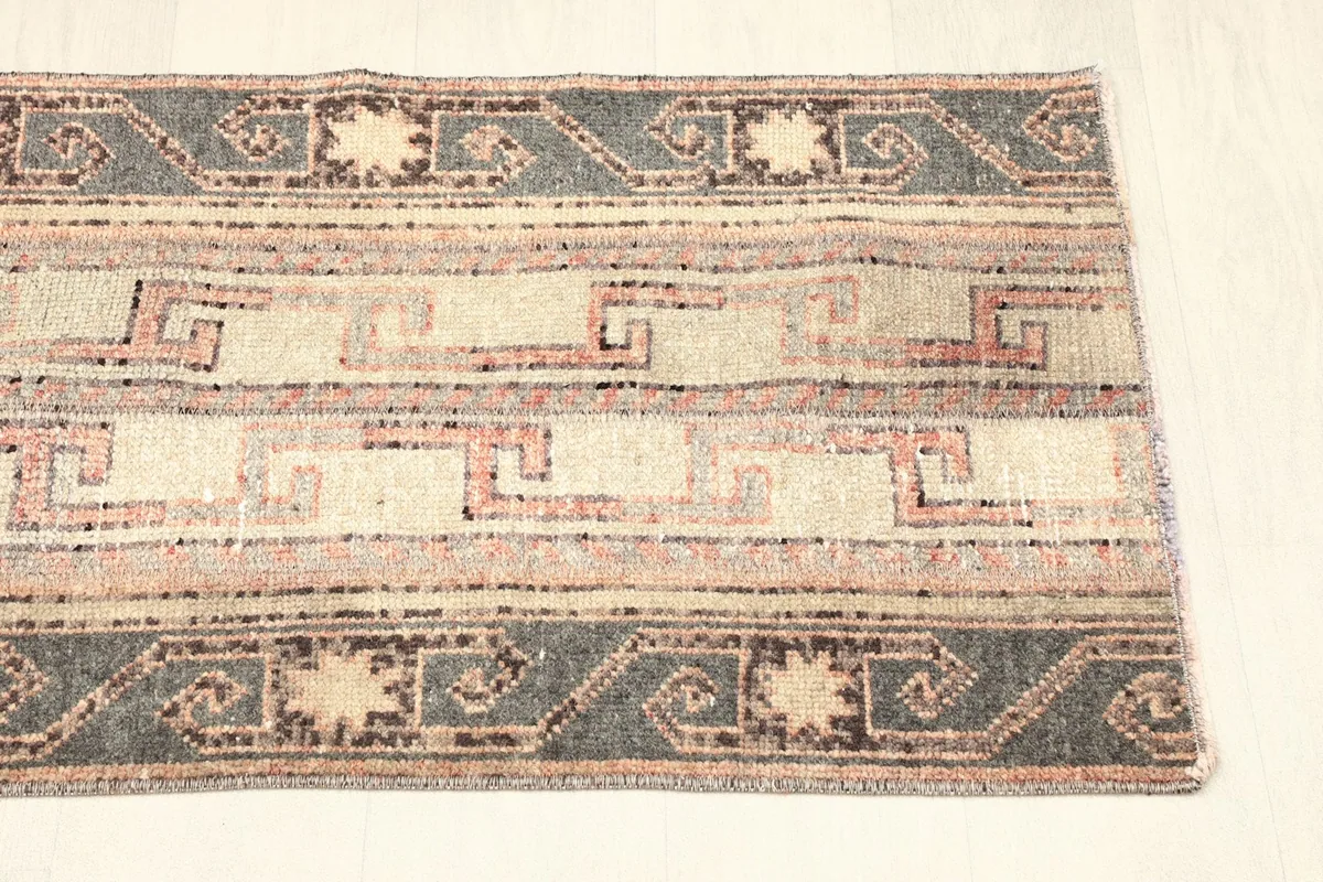 View of the other end of the rug, showing the consistent border pattern and condition
