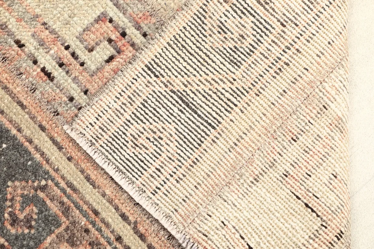 Close-up of the rug's reverse side, showing the cotton foundation and hand-knotted construction