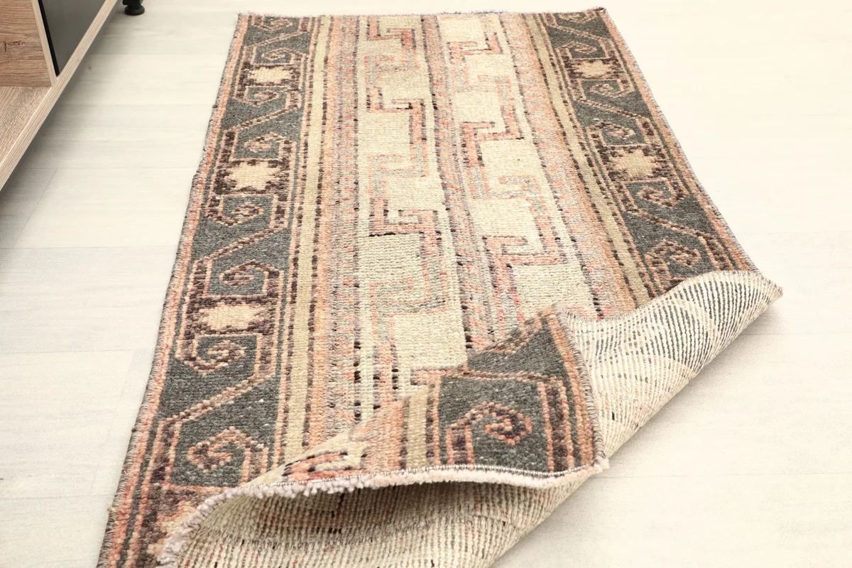 Rug partially folded, displaying its flexibility and showing the back and pile