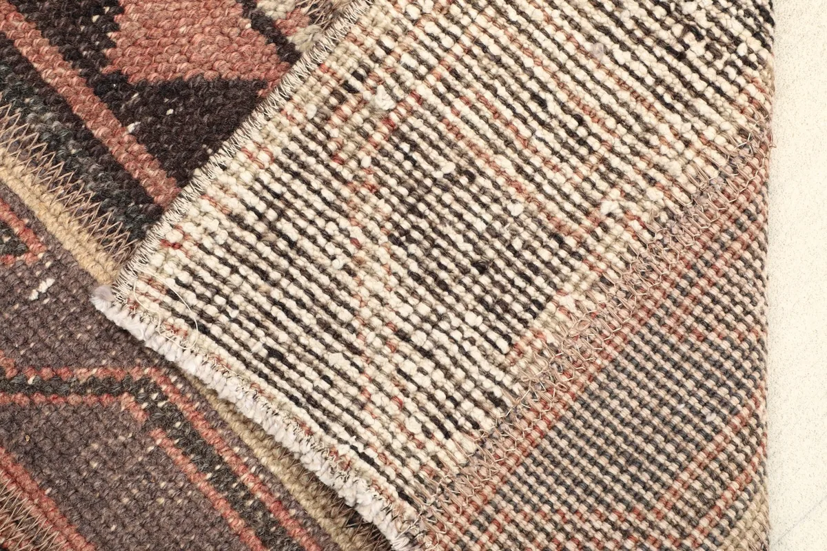 Close-up of the rug's underside, revealing the cotton foundation and hand-knotted construction.