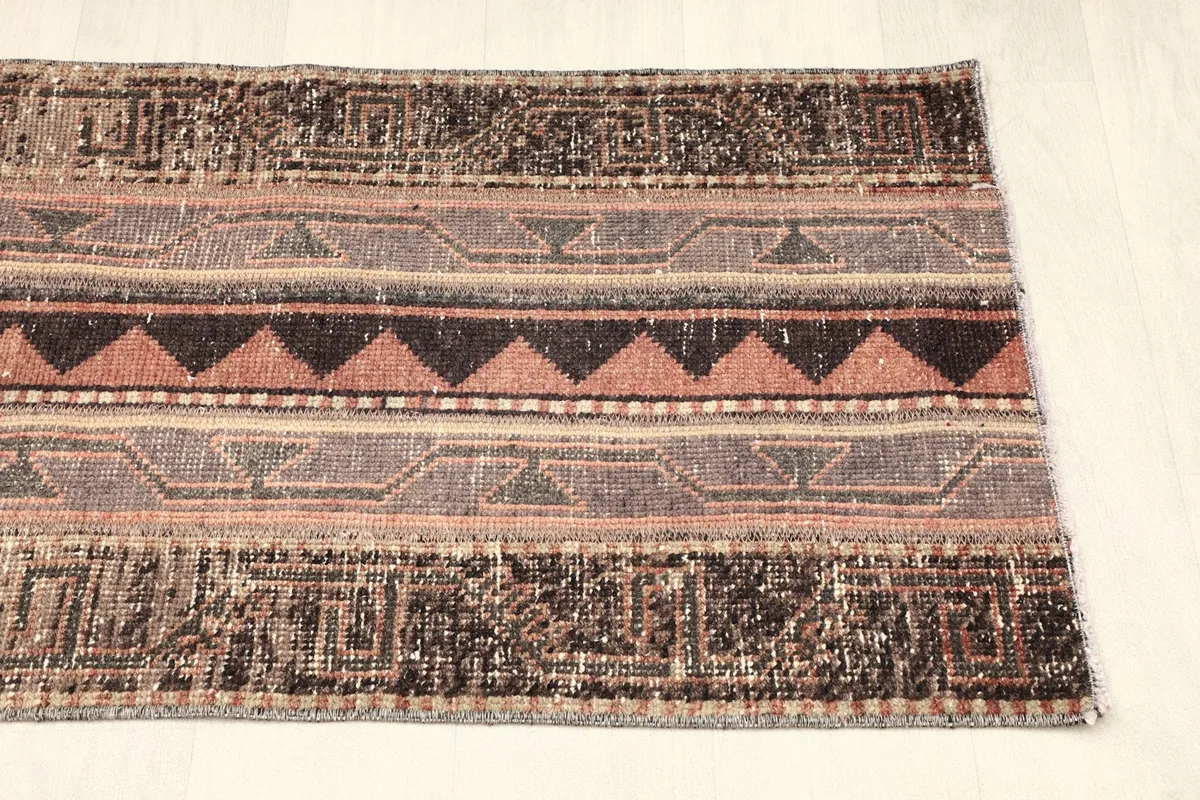 Angled shot of the opposite end of the rug, detailing the distressed look and patterns.