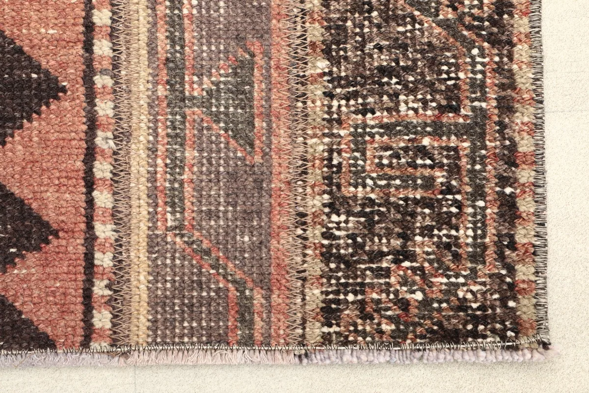 Close-up of the rug's edge, showing the hand-knotted texture and distinct pattern sections.