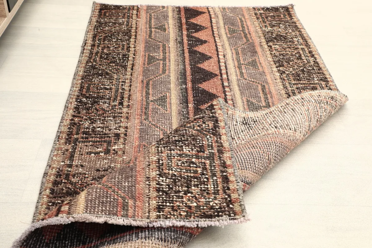 The rug partially folded, showing its flexibility and the reverse side's weave.