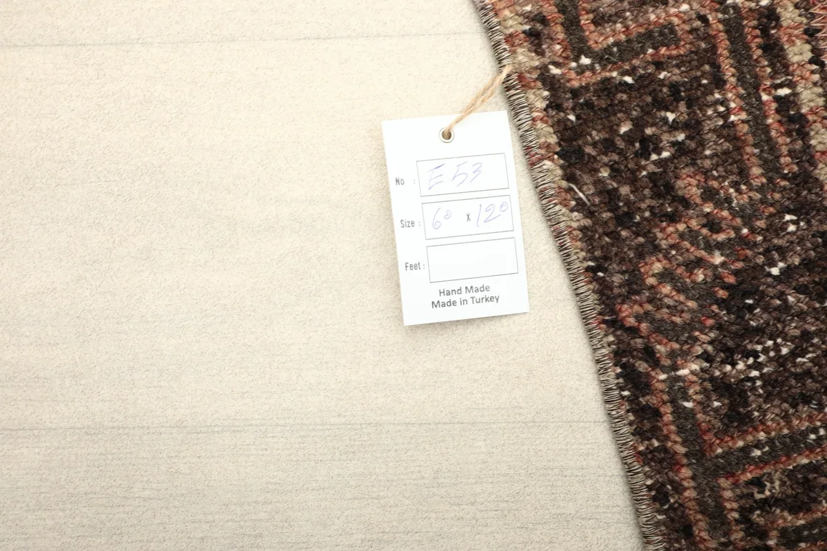 Close-up of the rug's corner with a 'Hand Made in Turkey' tag, indicating its origin.