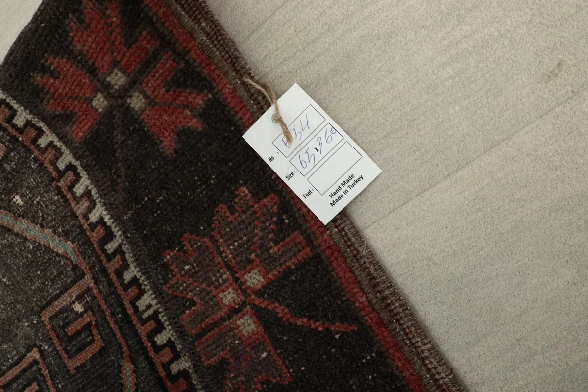 Close-up of the rug's edge with a size tag, confirming hand-knotted origin from Turkey