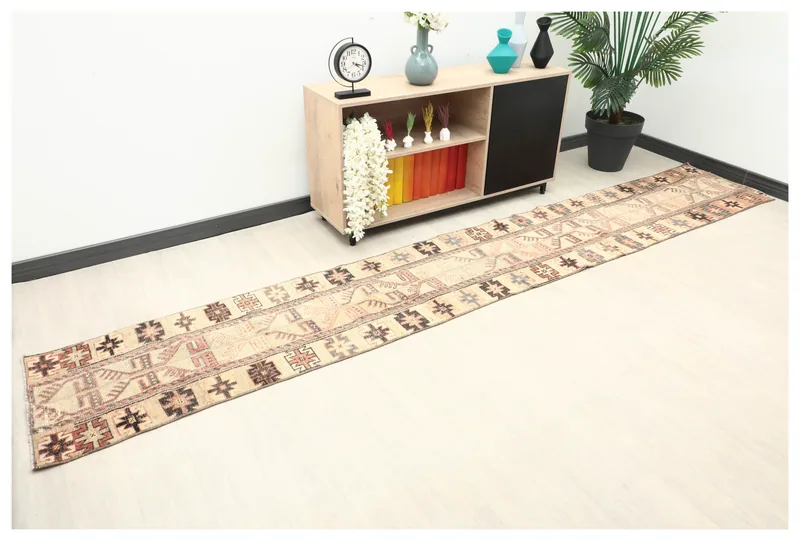 Full overhead view of the beige and rust geometric vintage runner on a white floor