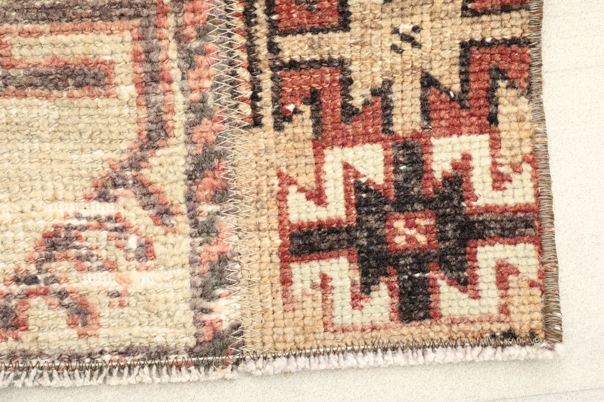 Close-up of a corner showing the geometric patterns, fringe, and edge finishing