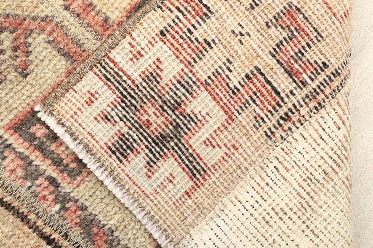 View of the back of the hand-knotted rug, revealing the cotton foundation and knotting