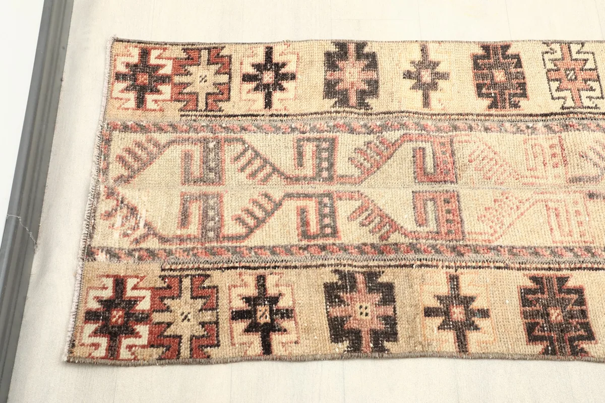 Close-up overhead view of the runner's beige field with rust and black geometric patterns