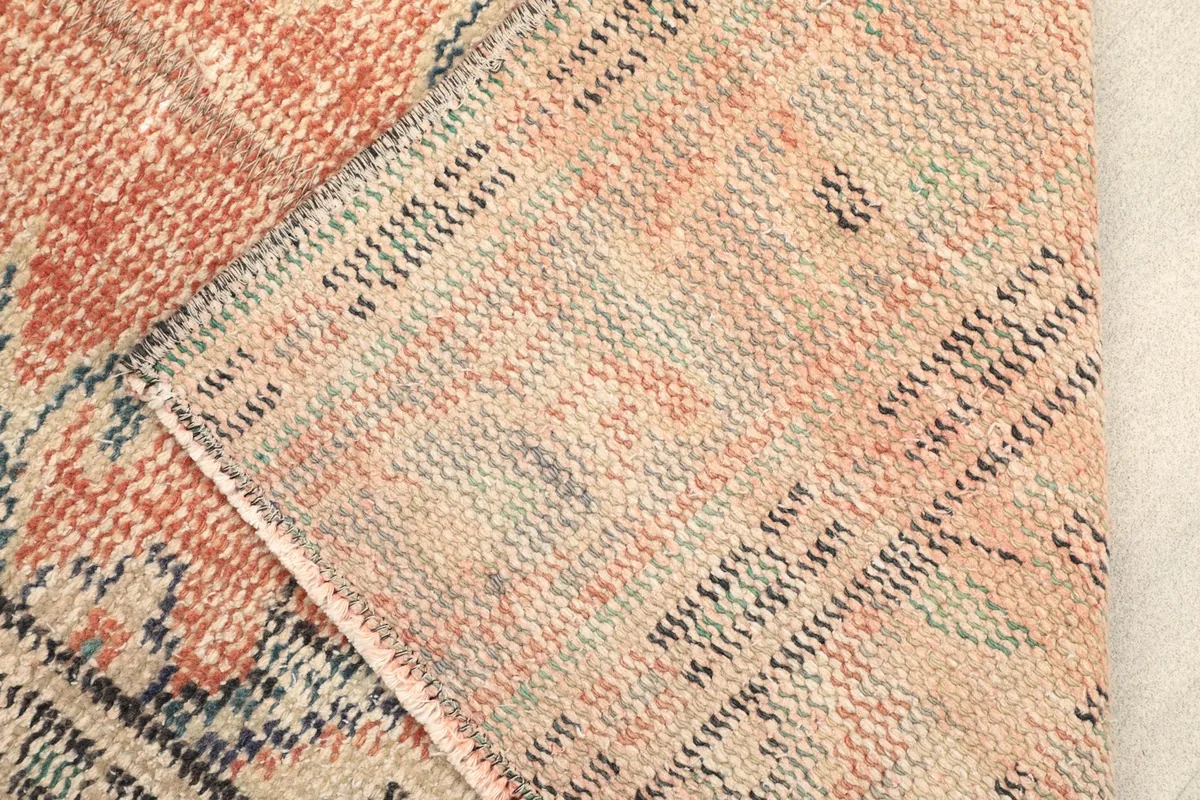 Close-up of the rug's back, displaying the hand-knotted cotton foundation.