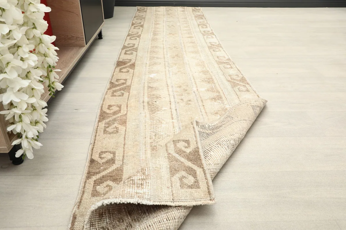 A section of the rug folded back, demonstrating its flexibility and the quality of the wool pile.