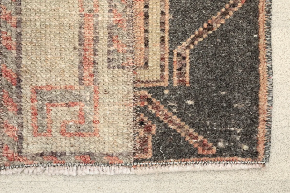 Close-up detail of the rug's corner, showing the hand-knotted wool pile and fringe.